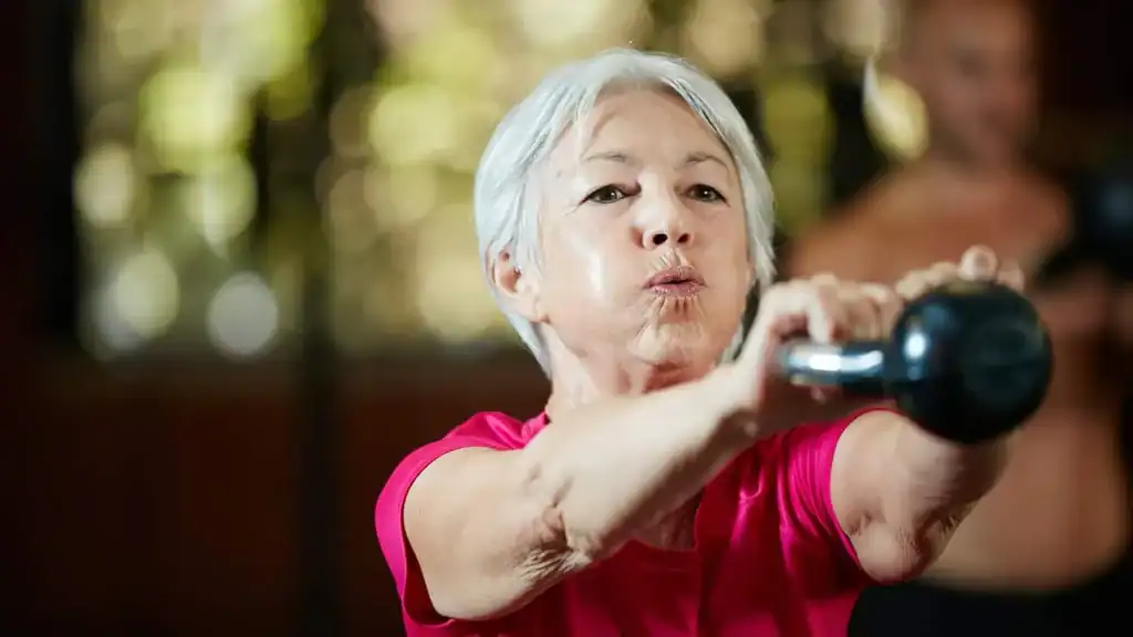 Older woman doing weight training Scotland to help her strength and longevity 