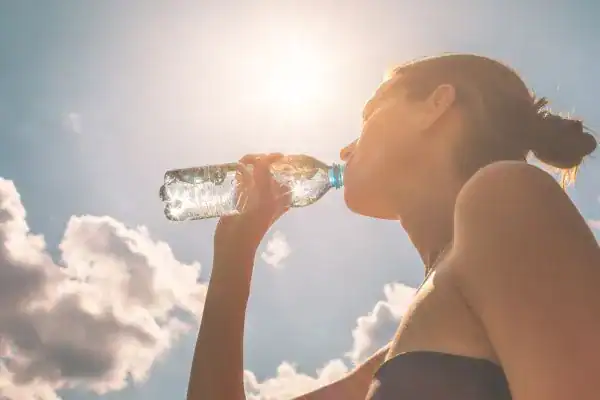 Hydration: The Secret Ingredient for a Toned Stomach and Enhanced Fitness 3 Image of woman drinking water to hydrate Scotland after run.