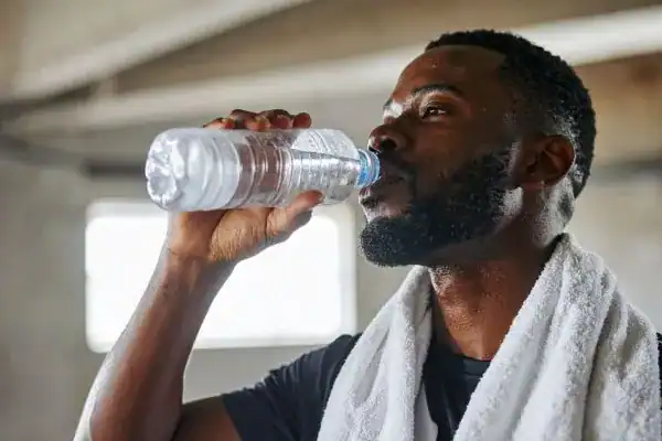 Hydration: The Secret Ingredient for a Toned Stomach and Enhanced Fitness 1 Image of man drinking water to improve hydration Scotland after work out.